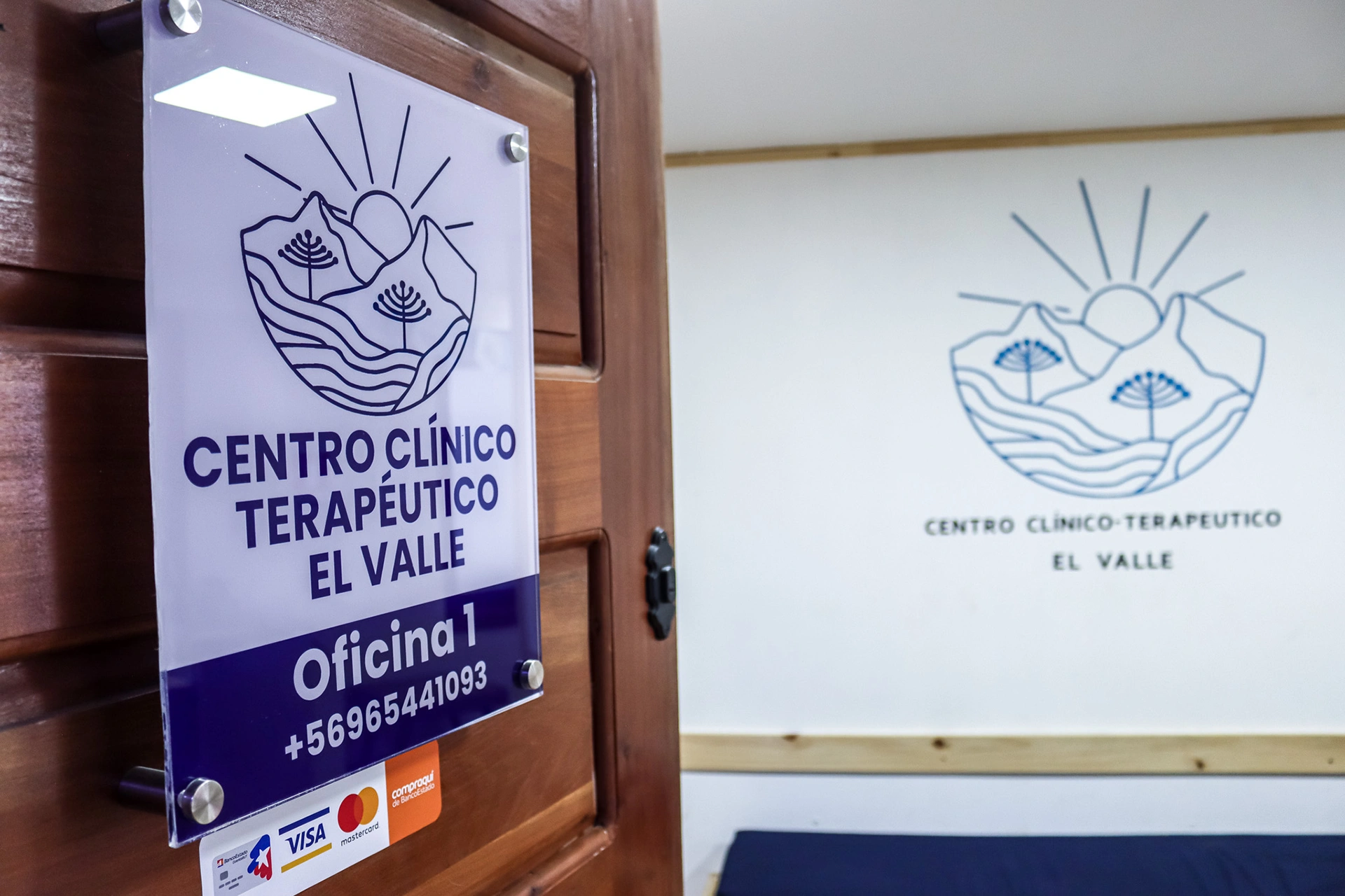 Puerta de la oficina 1 con afiche corporativo del centro y pizarra con logo del Valle